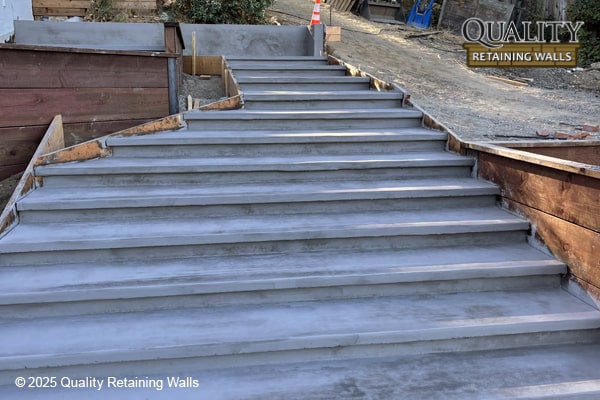 Poured concrete stairs integrated with wood retaining walls in Moraga hillside property