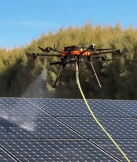 Drone cleaning solar panels on a rooftop array